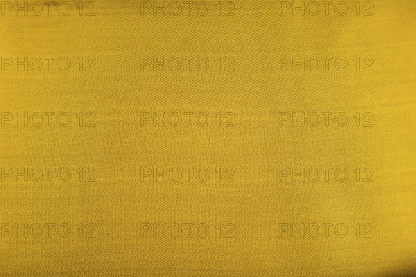 Fragment of smooth yellow and green tissue. Top view, flat lay, synthetic textile background and
