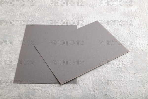 Gray paper business card, mockup on gray concrete background. Blank, flat lay, top view, still