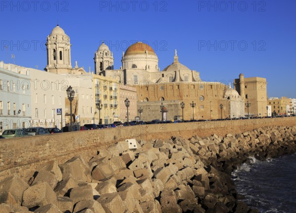 Coastal view east of rock armour coastal defences and cathedral, Cadiz, Spain, Europe