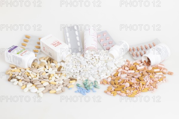 Various pills and tablets distributed around open medicine bottles