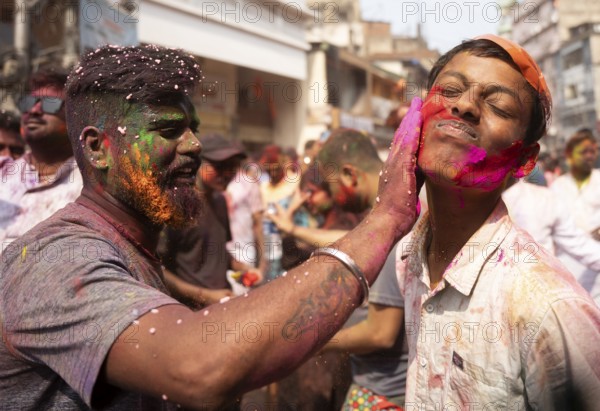 People smear colours eachother as they celebrate Holi on a street, the Hindu spring festival of