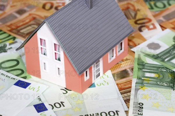 Concept photo with model house, euro notes and coins