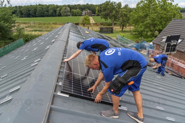 Installation of solar modules on the roof of a barn on a farm, over 240 photovoltaic modules are