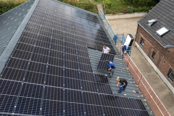Installation of solar modules on the roof of a barn on a farm, over 210 photovoltaic modules are