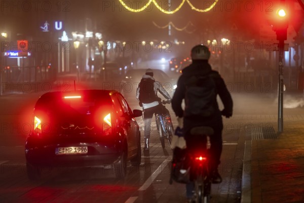 Cyclist, darkness, inner city traffic, Rüttenscheider Straße, bicycle lane, fog, autumn, winter,