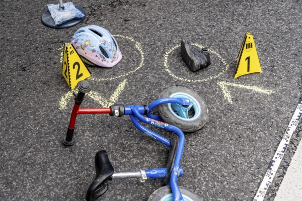 Markings at an accident scene with a balance bike for children, helmet, reenacted accident