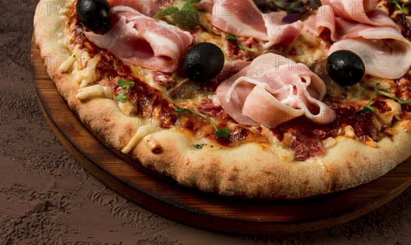 Pizza with prosciutto and mushrooms, bacon, olives, homemade, top view, no people