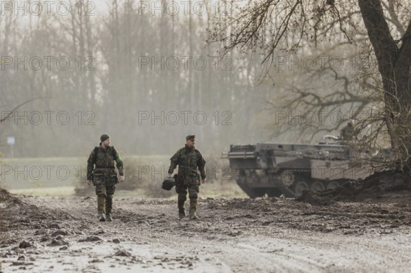 Two soldiers walking on a muddy path, taken as part of the military exercise 'Wettiner Schwert'