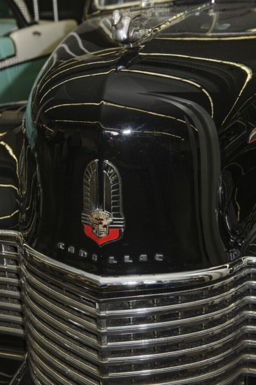 Bonnet with old historic logo underneath radiator grille of vintage classic car historic Cadillac,