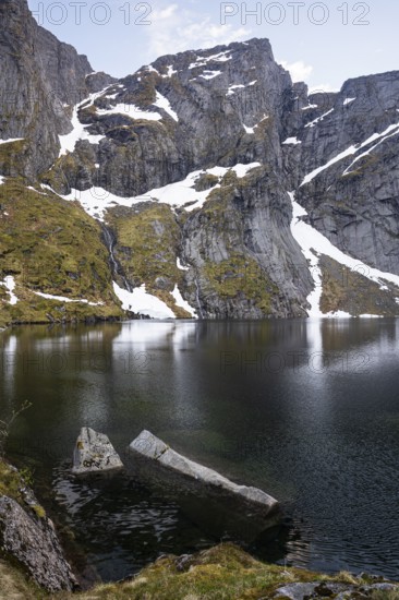 Lake Reinevatnet is located on the Reinebringen mountain. Rock faces with remnants of snow in early