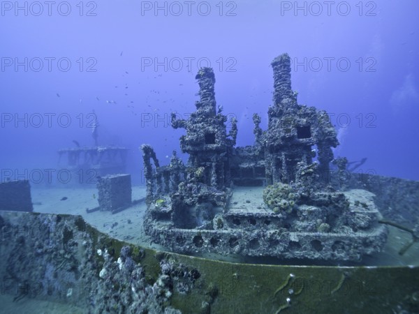 A complex underwater structure reclaimed by nature with visible coral growth: Wreck of the USS