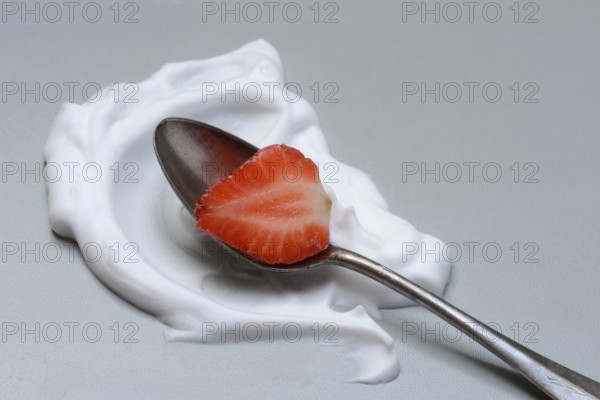 Strawberry with cream on a spoon