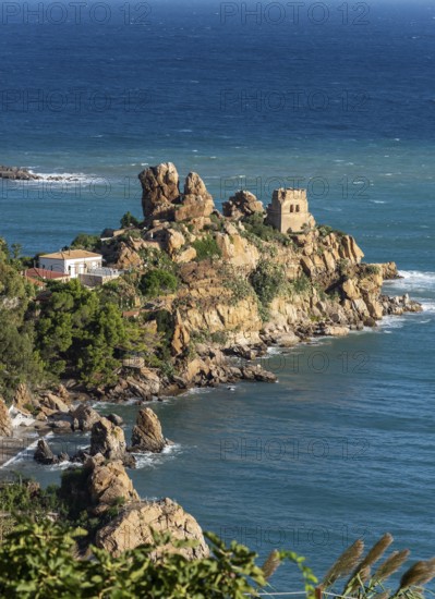 Ruins of Torre Caldura Castle on a rocky promontory jutting into the sea near Cefalu, Sicily,