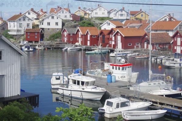 Harbour with several boats and traditional Scandinavian wooden houses, quiet atmosphere in a