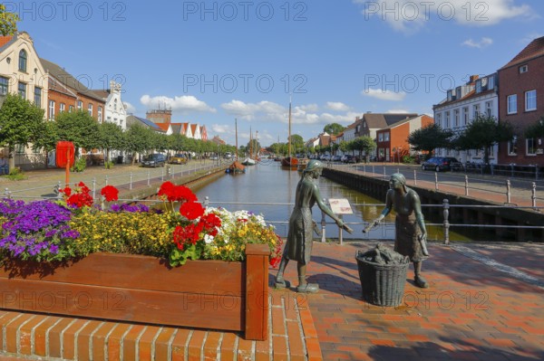 Old harbour with the bronze sculpture 'Törfwieven' in Weener, East Frisia, Lower Saxony, Germany,