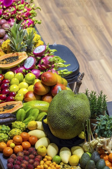 Exotic fruits, lychee, jackfruit, dragon fruit, mango and citrus fruits presented on a table,