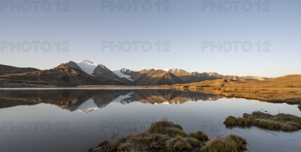 Glaciated mountain peaks reflected in a mountain lake at sunset, Arabel Lake at Arabel Pass, Issyk