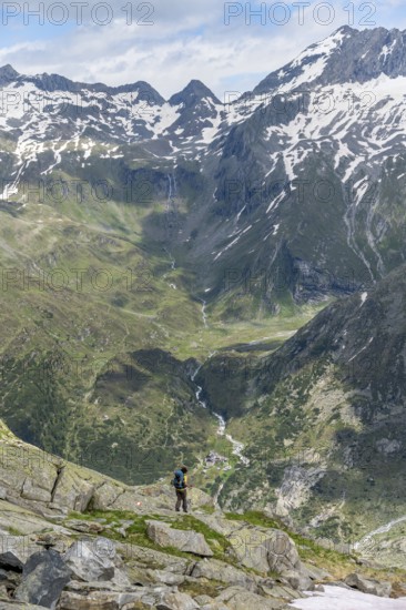 Mountaineer in front of picturesque mountain landscape, view of mountain hut Berliner Hütte with