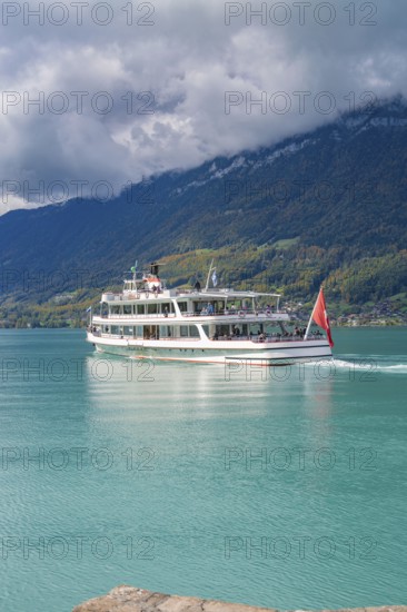 Large boat on a lake, forested mountains and clouds in the background, Lake Brienz, Switzerland,