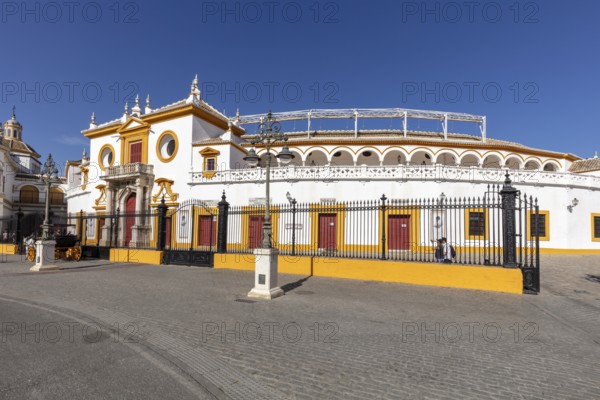 Round bullring with yellow and white details under a clear sky, Seville