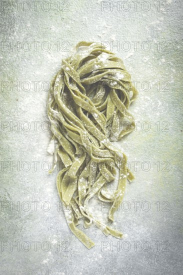 Raw tagliatelle pasta, with spinach, homemade, top view, no people, rustic style, cooking concept