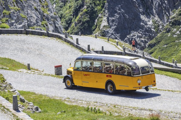 Historic postbus travelling along the Tremola, the world-famous serpentine road through the Val