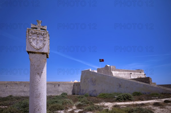 Memorial stone in honour of Henry the Navigator, Fortaleza de Sagres sea fortress, Portuguese flag,