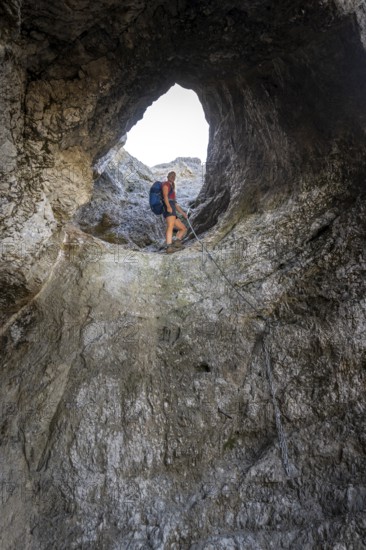 Hiker climbing through the Schindertor, Schinder, Tegernsee mountains in the Mangfall mountains,