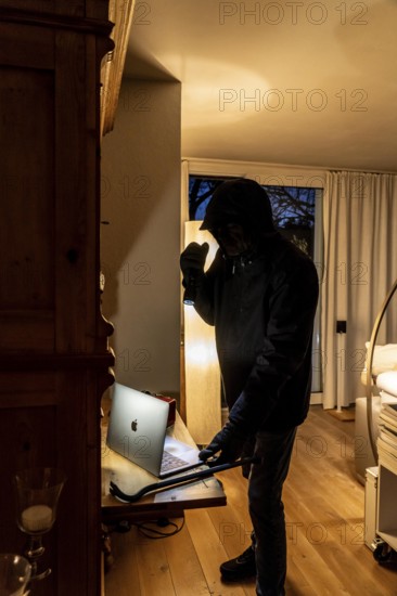 Symbolic image of a burglary, perpetrator has broken into a flat from the garden side and is