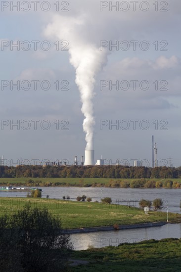 View of the green banks of the Rhine and white column of smoke from the cooling tower of the