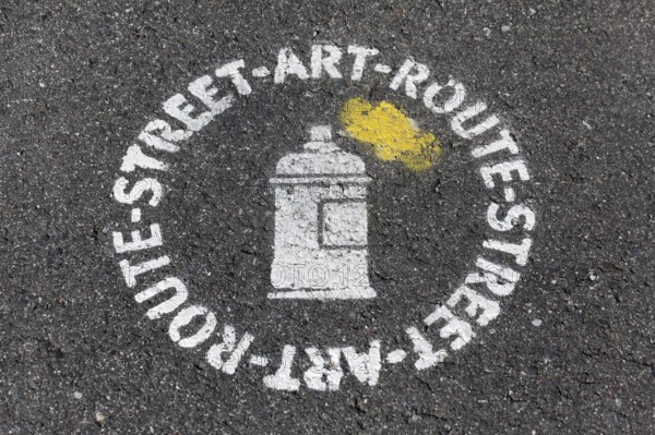 Street art route, stencil image on the asphalt as a signpost, urban art, Düsseldorf, North