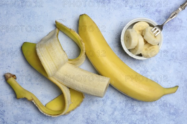 Opened banana and banana slices in peel