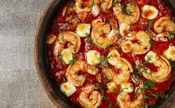 Saganaki with shrimp, in a clay pan, Greek dish, shrimp in tomato sauce, feta cheese, homemade, no