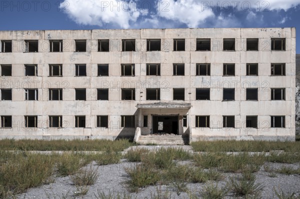 Entrance to an abandoned, destroyed residential building, old Soviet apartment blocks in the ghost