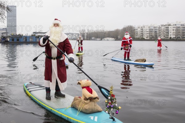 Water sports enthusiasts dressed as Santas ride SUPs on the Spree in Berlin on 14 December 2024