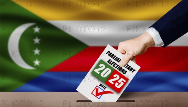 Hand holding ballot in voting ballot box with Comoran flag in background. Comoran parliamentary
