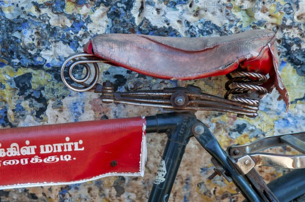 Red bicycle saddle, bicycle in front of blue-yellow wall, Karaikkudi, Tamil Nadu, India, Asia