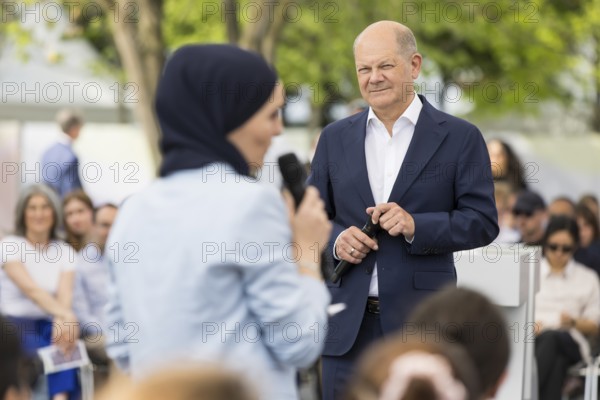 Olaf Scholz (Federal Chancellor, SPD) in conversation with a lady with a headscarf at the Germany