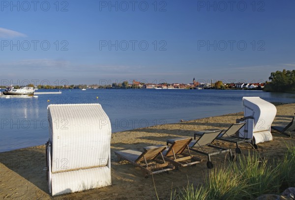 Empty beach with beach chairs and deckchairs on the lakeshore, autumn, Waren National Park,
