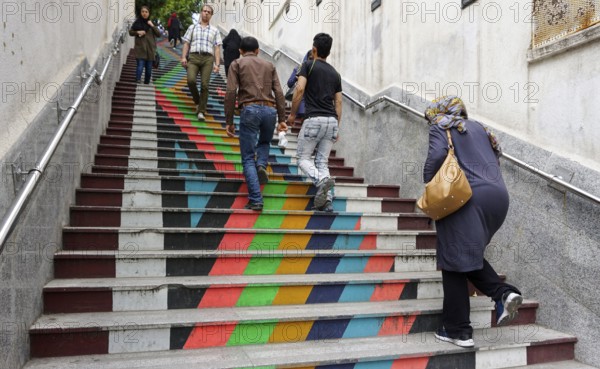 People walk down a painted staircase. The city of Tehran is changing the image of the city through
