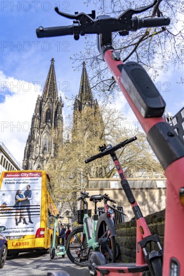 Electric scooters, e-scooters are parked in large numbers on the Burgmauer road, in front of
