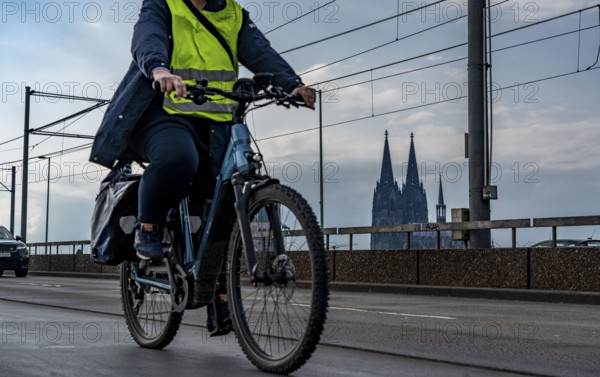 Cycling in the city, cyclist on the Deutzer Bridge in Cologne, Cologne Cathedral, cycle path, North