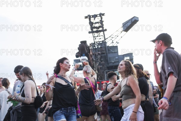Celebrating visitors in front of excavators at the Melt Festival in Ferropolis on 12 July 2024.