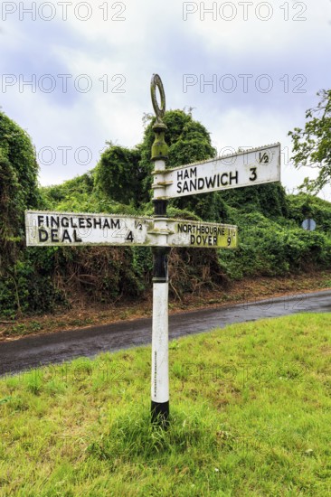 Old moss-covered signposts in the countryside, showing direction and distance to Ham, Sandwich and