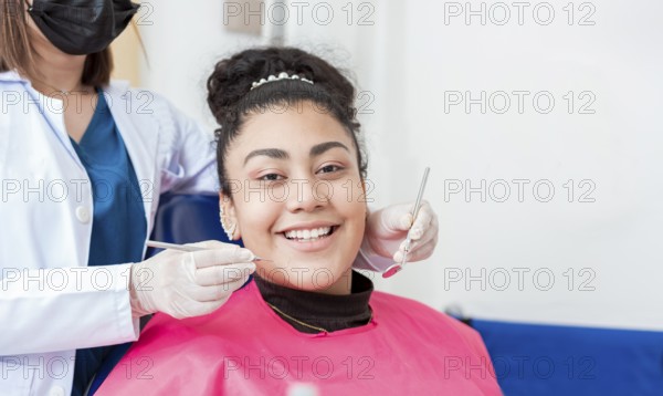 Dentist doctor examining mouth to female patient looking at camera. Dentist with probe and dental