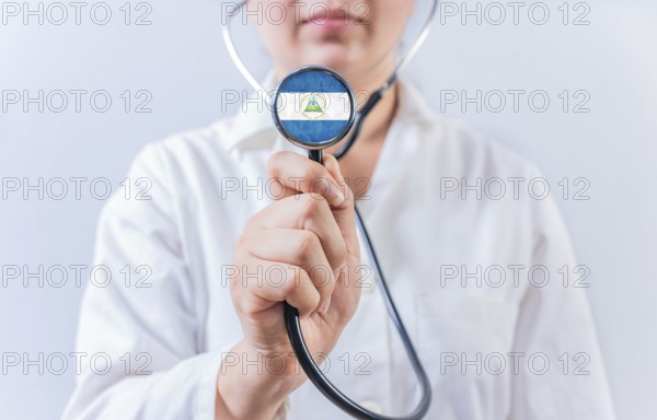 Female doctor holding stethoscope with Nicaragua flag. Nicaraguan Health and Care concept