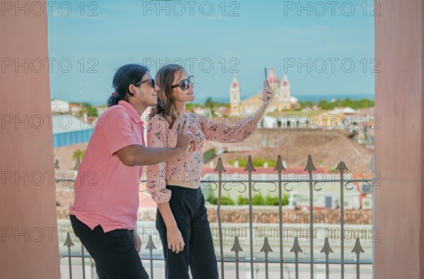 Tourist couple taking a selfie at the viewpoint of the La Merced church. Happy tourists taking self