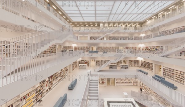 Modern, bright library with open staircases and many bookshelves in a symmetrical arrangement,