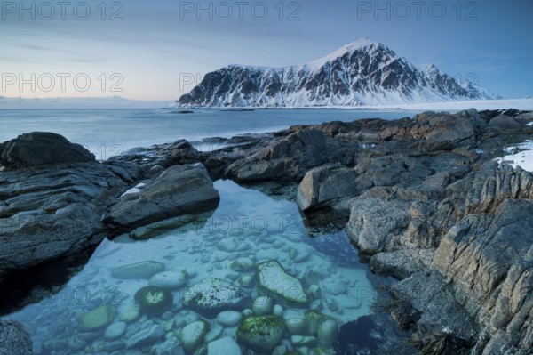 Long exposure, winter at Skagsanden, rocks washed over by the sea on the beach at Flakstad,