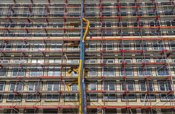 Large construction site, scaffolded shell of an office building complex, air hoses for building